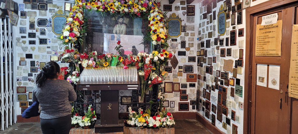 Kapelle mit Blumen geschmückt, Frau betet